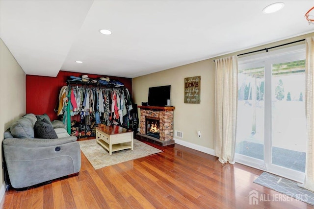 16 Dutch Valley Rd, Howell, NJ 07731 - living area with wood finished floors, recessed lighting, a stone fireplace, and baseboards