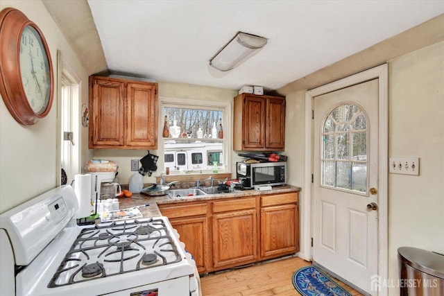 54 E Greystone Rd, Old Bridge, NJ 08857 - kitchen featuring white range with gas cooktop, light wood-style floors, stainless steel microwave, brown cabinetry, and a sink