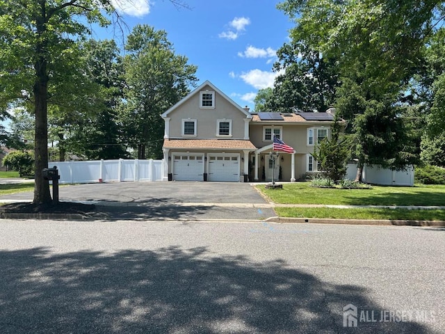 364 Grandview Ave, Piscataway, NJ 08854 - view of front of home featuring stucco siding, solar panels, an attached garage, and asphalt driveway
