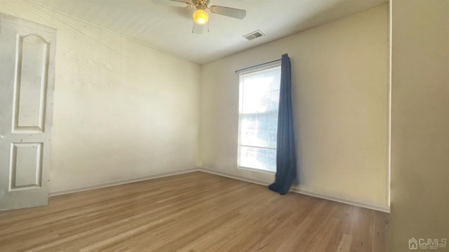 empty room with ceiling fan, plenty of natural light, and light wood-type flooring