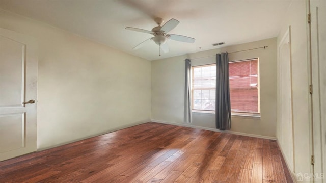 spare room featuring ceiling fan and dark hardwood / wood-style flooring