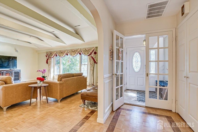 entrance foyer with parquet flooring, french doors, and vaulted ceiling with beams