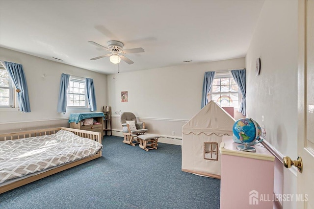 carpeted bedroom featuring ceiling fan and baseboard heating