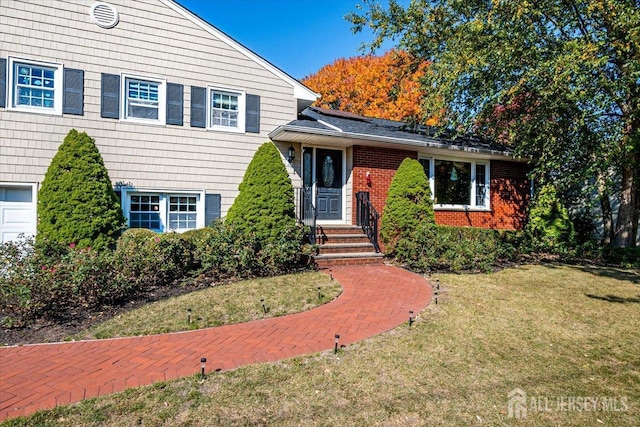 split level home with a garage and a front lawn