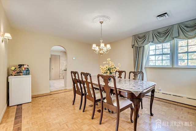 dining space with a chandelier, a baseboard heating unit, washer / dryer, and light parquet floors