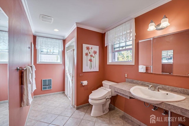 bathroom with toilet, tile patterned flooring, heating unit, ornamental molding, and sink