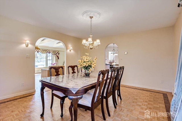 dining room with light parquet floors and a chandelier