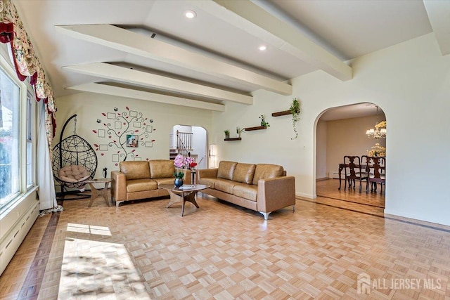 living room featuring beamed ceiling, an inviting chandelier, and light parquet floors