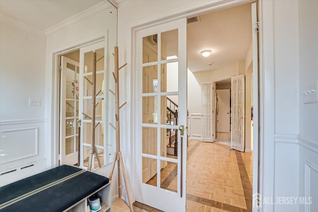 doorway featuring parquet floors, ornamental molding, and french doors