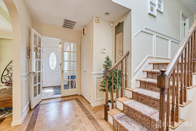 foyer entrance featuring light parquet flooring and french doors