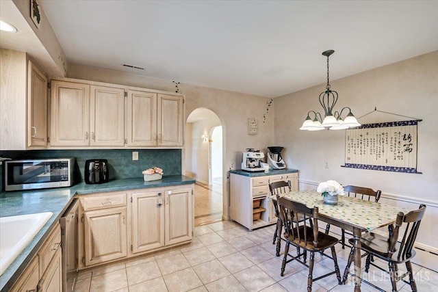 kitchen featuring pendant lighting, appliances with stainless steel finishes, light brown cabinetry, and light tile patterned floors