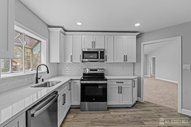 3 Bristol Ct Unit D, Monroe, NJ 08831 - kitchen with stainless steel appliances, a sink, light countertops, tasteful backsplash, and light wood-style flooring