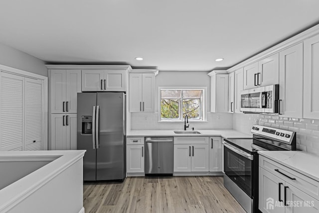3 Bristol Ct Unit D, Monroe, NJ 08831 - kitchen with stainless steel appliances, a sink, light wood-style flooring, backsplash, and recessed lighting
