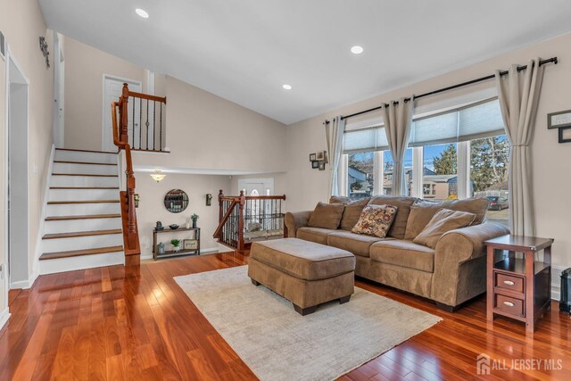 living room featuring wood-type flooring and vaulted ceiling