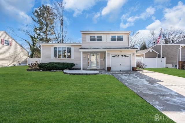 tri-level home with a garage, concrete driveway, a front lawn, and fence