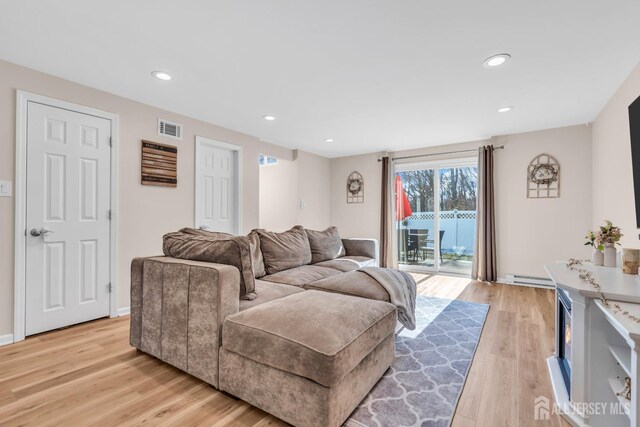 living room featuring a baseboard radiator and light hardwood / wood-style floors