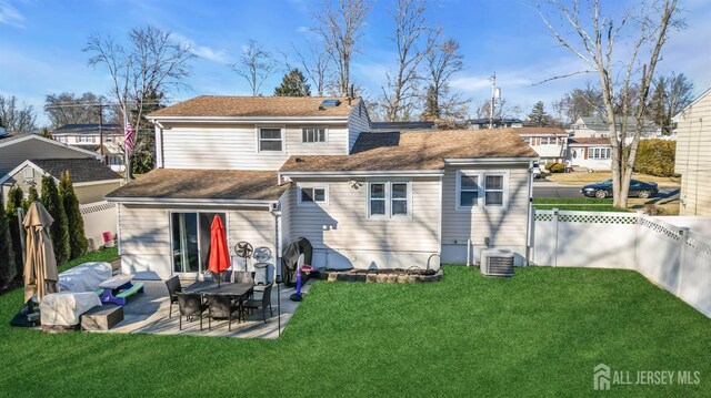 back of property with central AC, a patio area, and a lawn