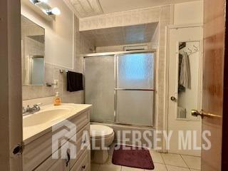 bathroom featuring vanity, toilet, and tile patterned flooring