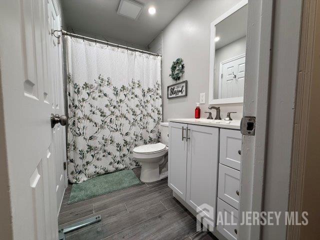 13 Heritage Ln, Fords, NJ 08863 - full bathroom featuring toilet, vanity, wood finish floors, and a shower with curtain