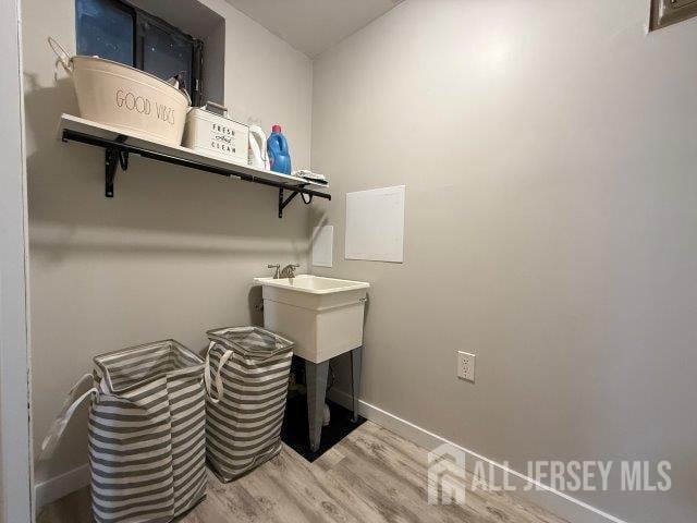13 Heritage Ln, Fords, NJ 08863 - laundry area with wood finished floors, baseboards, and a sink