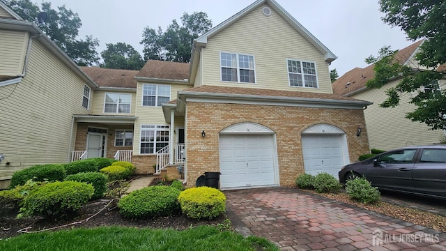 76 Tennyson Rd, East Windsor, NJ 08520 - view of front of property with a garage, brick siding, decorative driveway, and roof with shingles