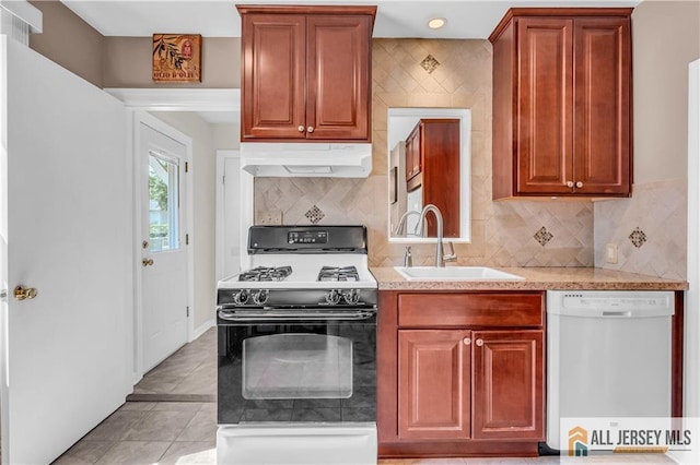 706 Wood Ave, North Brunswick, NJ 08902 - kitchen featuring white dishwasher, under cabinet range hood, gas range oven, light countertops, and backsplash