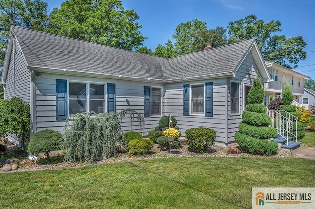 706 Wood Ave, North Brunswick, NJ 08902 - view of front of house featuring a shingled roof, a front lawn, and a chimney