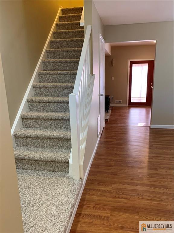 stairs with hardwood / wood-style flooring