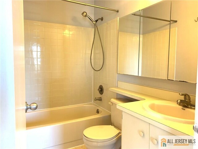 full bathroom with toilet, vanity, and tiled shower / bath combo