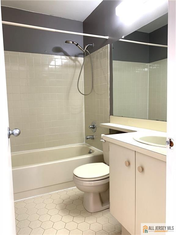 full bathroom with vanity, bathtub / shower combination, tile patterned floors, and toilet