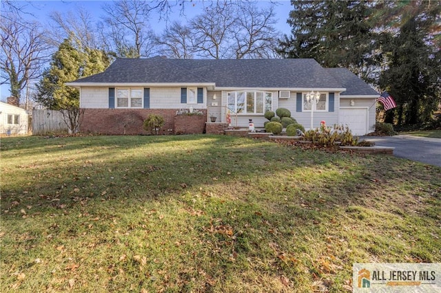 ranch-style home featuring a garage and a front lawn