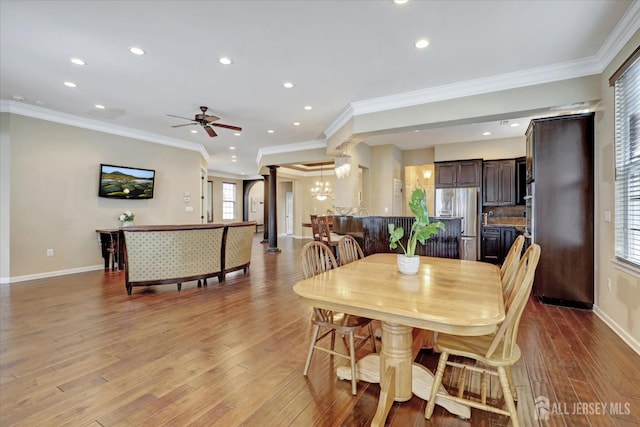 dining room with recessed lighting, healthy amount of natural light, ornamental molding, wood finished floors, and a chandelier
