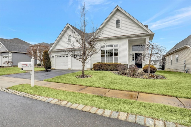 view of front facade with an attached garage, aphalt driveway, and a front yard