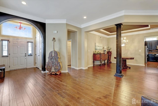 entrance foyer with plenty of natural light, wood finished floors, a chandelier, decorative columns, and recessed lighting
