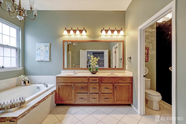 full bathroom featuring tile patterned flooring, a garden tub, a chandelier, and toilet