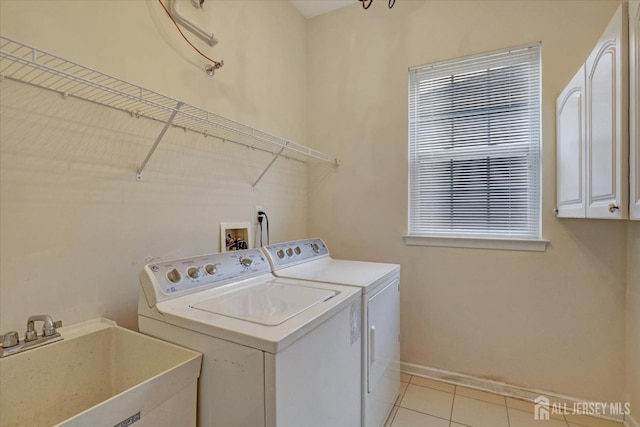 laundry area with cabinet space, independent washer and dryer, baseboards, and light tile patterned floors