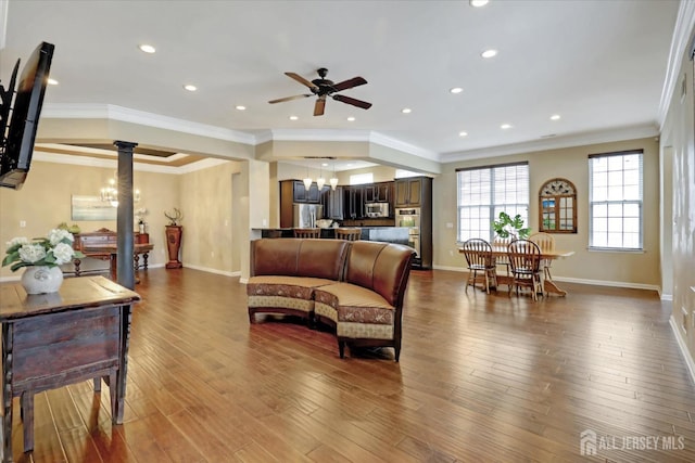 living room with a ceiling fan, baseboards, a chandelier, recessed lighting, and wood finished floors