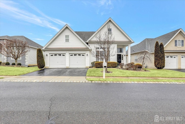 traditional home with asphalt driveway, a front yard, and a garage
