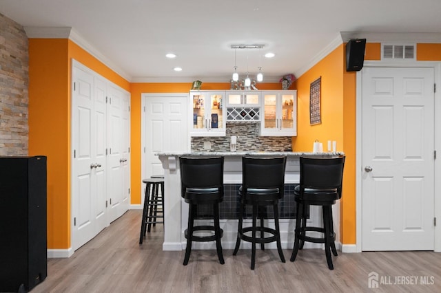 31 Morris Ln, Cranbury, NJ 08512 - indoor wet bar featuring light wood finished floors, ornamental molding, decorative backsplash, baseboards, and pendant lighting