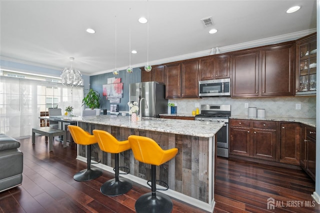 31 Morris Ln, Cranbury, NJ 08512 - kitchen with appliances with stainless steel finishes, a kitchen island with sink, dark wood finished floors, a kitchen bar, and light stone countertops