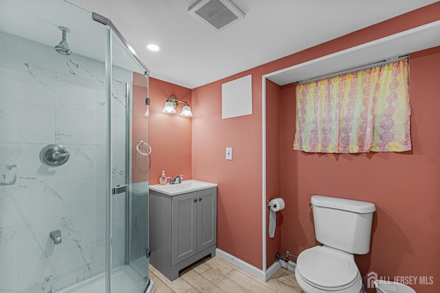 bathroom featuring a shower stall, toilet, vanity, baseboards, and recessed lighting