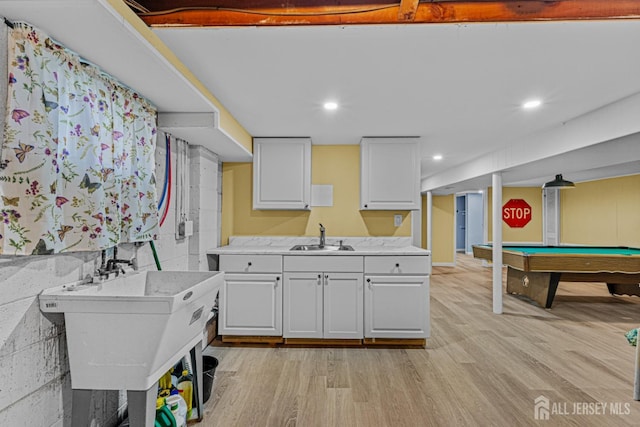kitchen featuring a sink, white cabinets, light countertops, light wood-style flooring, and recessed lighting