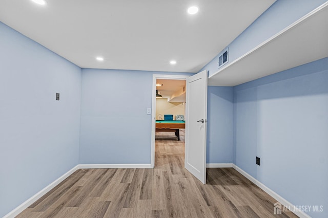 unfurnished room with wood finished floors, baseboards, and recessed lighting