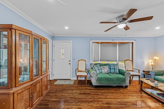 living area featuring dark wood-type flooring, crown molding, a ceiling fan, recessed lighting, and baseboards
