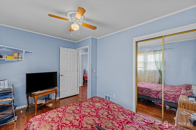 bedroom with ornamental molding, wood finished floors, ceiling fan, and a closet