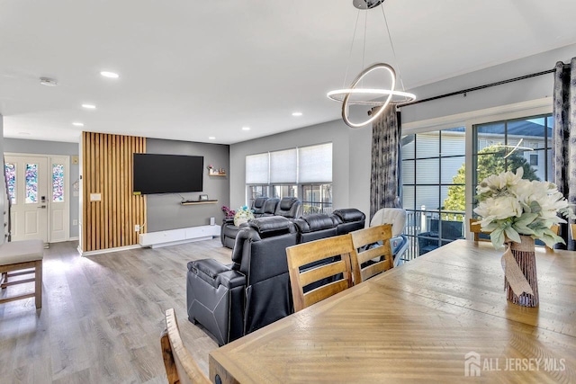 dining area with light hardwood / wood-style flooring, plenty of natural light, and a chandelier