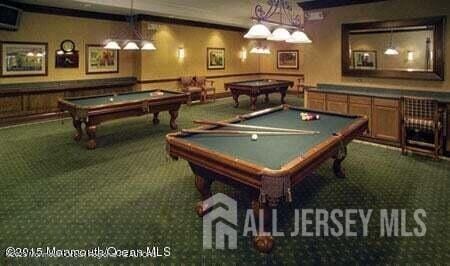 recreation room with pool table, crown molding, and dark carpet