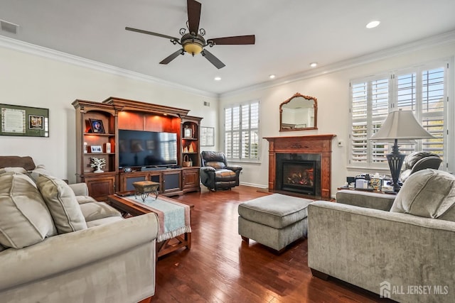 living room with dark wood-type flooring, crown molding, and a healthy amount of sunlight