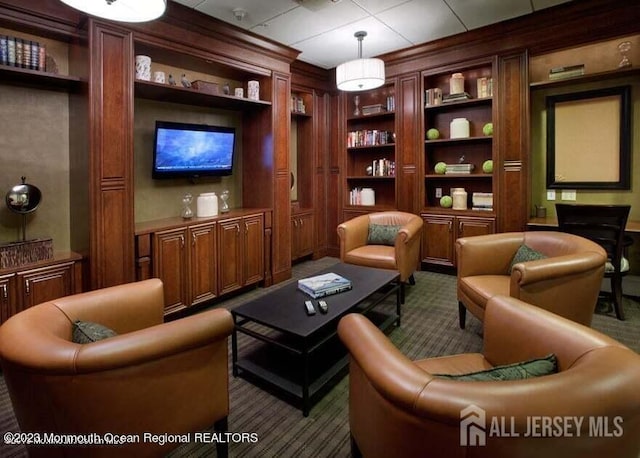 sitting room featuring carpet floors and built in shelves