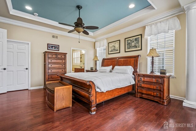 bedroom featuring ceiling fan, dark hardwood / wood-style flooring, ornamental molding, and a tray ceiling